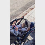 video showing wearabowl in use by a young child seated and buckled into their stroller snacking comfortably.